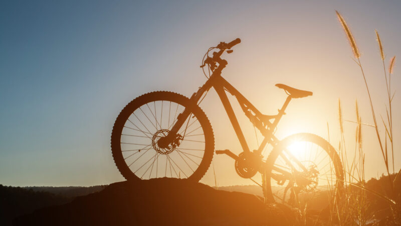 Silhouette Mountain biking on the rock at sky sunset